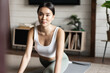Asian girl doing yoga stretching at home, workout in her living room, wearing activewear