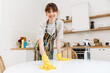 © Drobot Dean - White young woman in gloves smiling while cleaning table