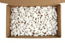 Styrofoam Packing Peanuts In Cardboard Box Isolated In On White Background. White Plastic Foam Pellets Protective For Parcel Packing.