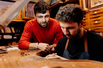 Two men work together in their small jewelry business. craftsmen working in the workshop