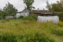 Neglected Untidy Village Scene, Overgrown Grass, Plastic Greenhouse, Some Old Houses