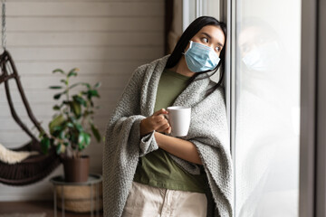 Wall Mural - Asian girl in medical face mask, yearning go outside, being sick with covid 19 and staying on self quarantine in her house