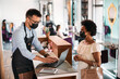 © Drazen - Hairstylist uses laptop while talking to African American customer at reception desk.