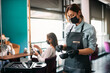 © Drazen - Hairstylist wearing face mask and prepares hair dye during appointment with customer at the salon.