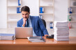 © Elnur - Young businessman employee and too much work in the office