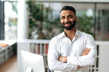 Portrait Happy Confident Smart Handsome Business Leader Of Indian Ethnic, Freelancer Or Top Manager With Beard Wearing White Formal Shirt, Standing In Office With Arms Crossed, Looks At Camera, Smile