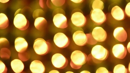 Wall Mural - Fiery play of golden bokeh on a black background. Round golden lights shimmer, move and fade in both directions against a dark background. Can be looped and use as background or overlay.