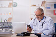© Elnur - Old male doctor working in the clinic