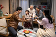© Blue Jean Images - Happy family grabbing red envelope with smart phones