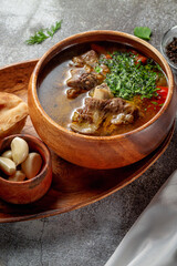 Canvas Print - Beef goulage with garlic and pita bread on a gray stone table, Flatlay