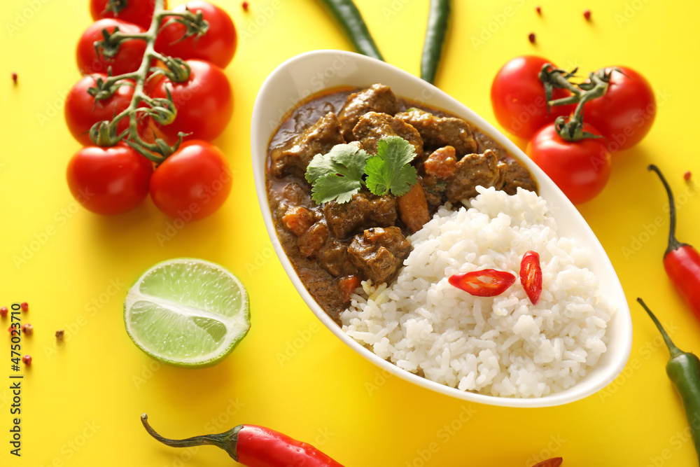 Plate with tasty beef curry and rice on color background