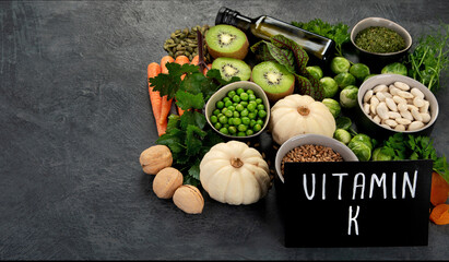 Wall Mural - Foods high in vitamin K on dark background.