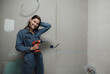 © kalinichenkod - a beautiful young woman makes repairs at home