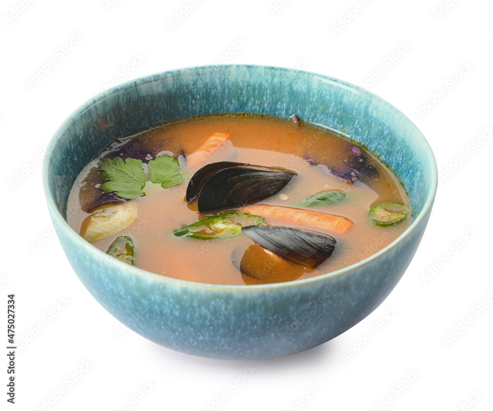Bowl of spicy Thai soup on white background
