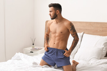 Wall Mural - Sexy young man in underwear on bed