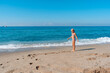 © mirkadirka - Blond preschool girl wearing colorful swimsuit near the sea on the sand beach on a beautiful summer sunny day.