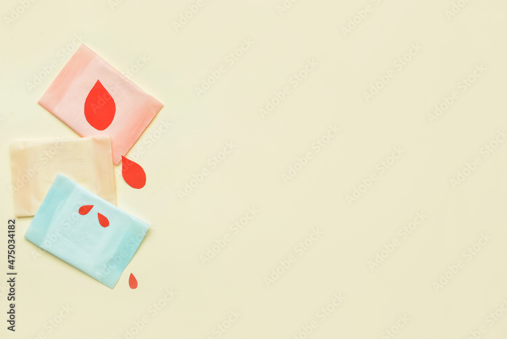 Menstrual pads and paper blood drops on light background