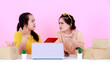 Portrait studio shot two Asian upset unhappy worried female startup small business entrepreneur businesswoman sitting together holding hands on head have problem losing customers on pink background