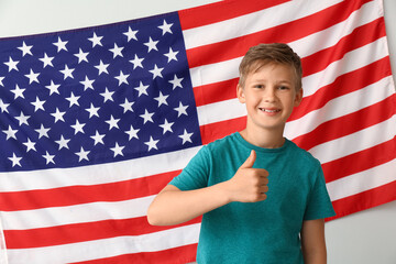 Wall Mural - Pupil of language school showing thumb-up near light wall with USA flag