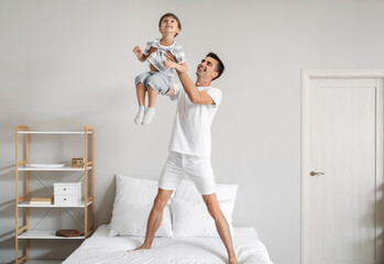 Canvas Print - Man and his little son dancing in bedroom