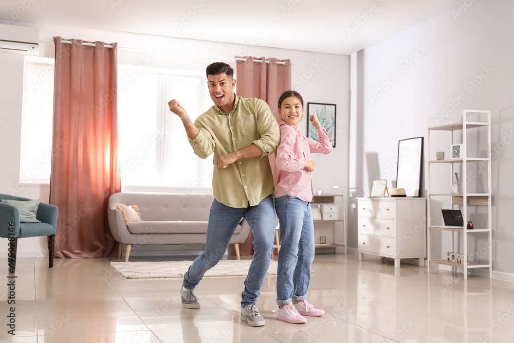 Man and his little daughter dancing at home