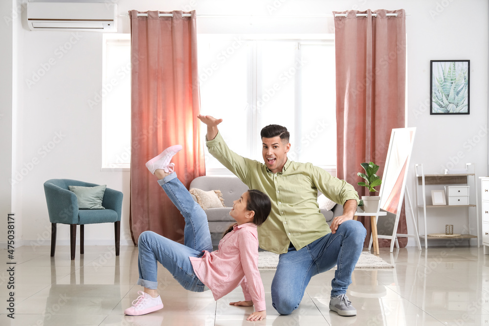 Man and his little daughter dancing at home
