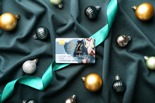 Gift Card, Christmas Balls And Ribbon On Color Fabric Background