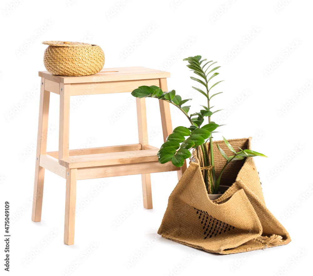 Wooden step stool with basket and houseplant on white background