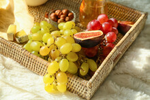Tray With Ripe Grapes And Snacks On Fabric Background, Closeup