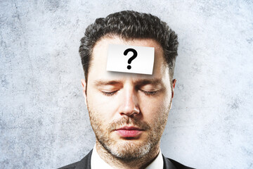 Aufkleber - Portrait of attractive young european businessman with question mark sticker on forehead. Concrete wall background. Solution and ask concept.