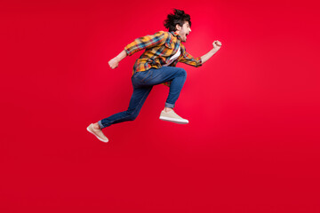 Sticker - Photo of pretty charming young gentleman wear plaid outfit smiling jumping high running fast isolated red color background