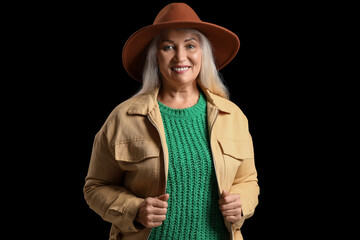 Canvas Print - Smiling mature woman in felt hat on dark background