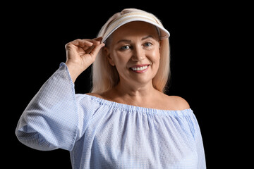 Sticker - Smiling mature woman in visor cap on dark background