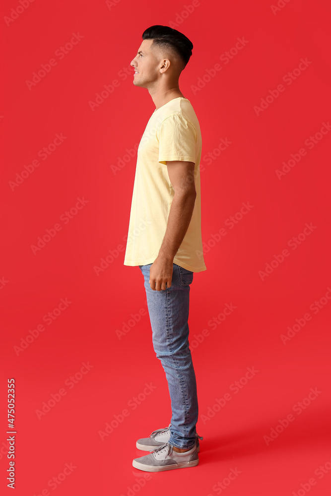 Handsome young man in stylish t-shirt on color background