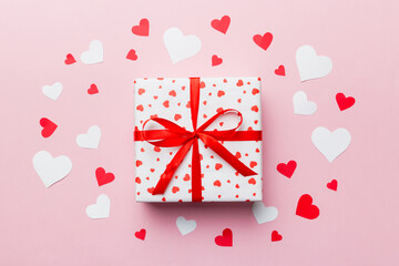 Valentine day composition Background: red gift box with bow and heart. Christmas present. View from above. Holday greeting card