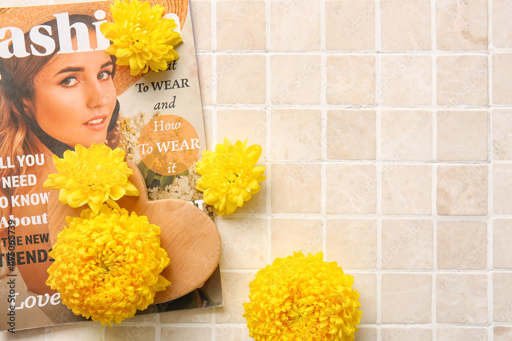 Yellow chrysanthemum flowers and magazine on light background