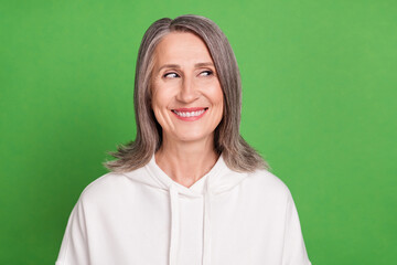 Poster - Photo of pretty thoughtful old woman dressed white sweatshirt smiling looking empty space isolated green color background