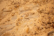© Оксана Скиданова - Textural sand, with  relief surface, multi-colored layers and different in size of granules, in outdoor sand career, after mining ore and sand for construction.