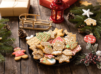 Wall Mural - Beautifully arranged cookies in winter holidays theme, merry Christmas and happy New Year, rustic wooden background, biscuits with sugar icing shaped in traditional winter motives