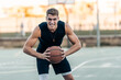 © Samuel Perales - Man posing with aggressive expression while holding a basketball outdoors