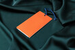 © New Africa - Blank orange tags on green silky fabric, closeup. Space for text