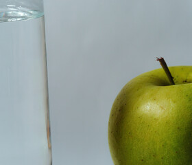 Sticker - Close-up photo of a glass of mineral water standing next to an apple