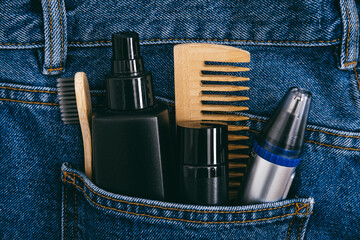 Men self care beauty kit, male beauty care cosmetic products and devices in blue jeans denim pocket. Man self care set with skin and hair care products.