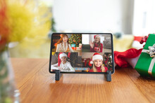 Smiling Caucasian Female Friends In Santa Hats On Tablet Group Video Call Screen At Christmas Time