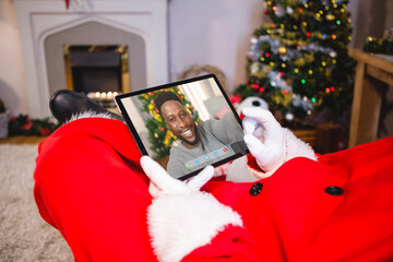 Poster - Santa claus making tablet christmas video call with smiling african american man