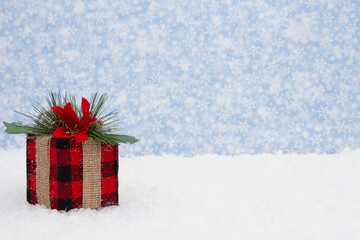 Wall Mural - Black and red plaid Christmas present and snow with snowy sky