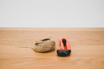 Poster - cutter and rough string on a wooden tabletop