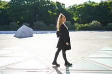 Young Woman Walking On Square Of City In Sunny Day