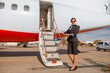 © Kostiantyn - Flight attendant standing near airplane and inviting on board
