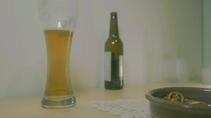 Wall Mural - Footage of a glass full of beer standing  on the table and a hand taking it